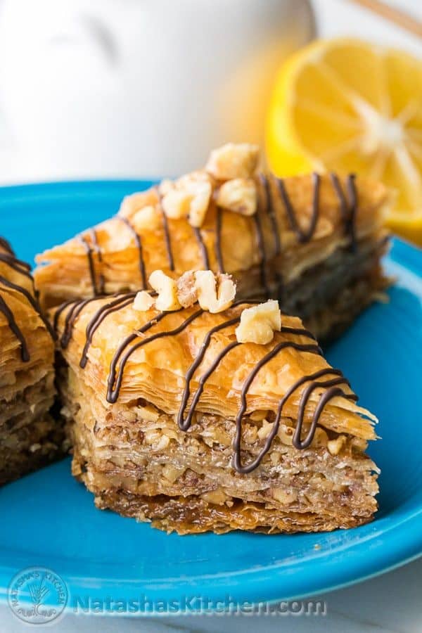 Baklava pieces loaded with nuts and honey lemon syrup with chocolate garnish - A center cut view of this homemade baklava recipe showing flaky, crisp, tender layers.