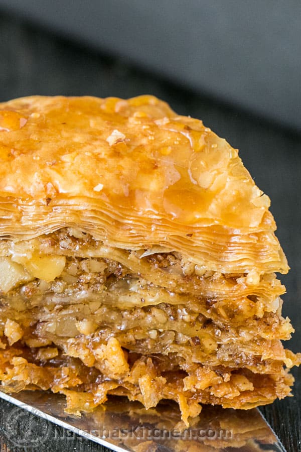 Up close view of baklava recipe showing nut and syrup filling with flaky crisp crust. 
