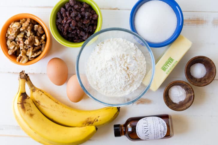 Ingredients for Banana Bread with ripe bananas, flour, sugar, eggs, butter, walnuts and raisins