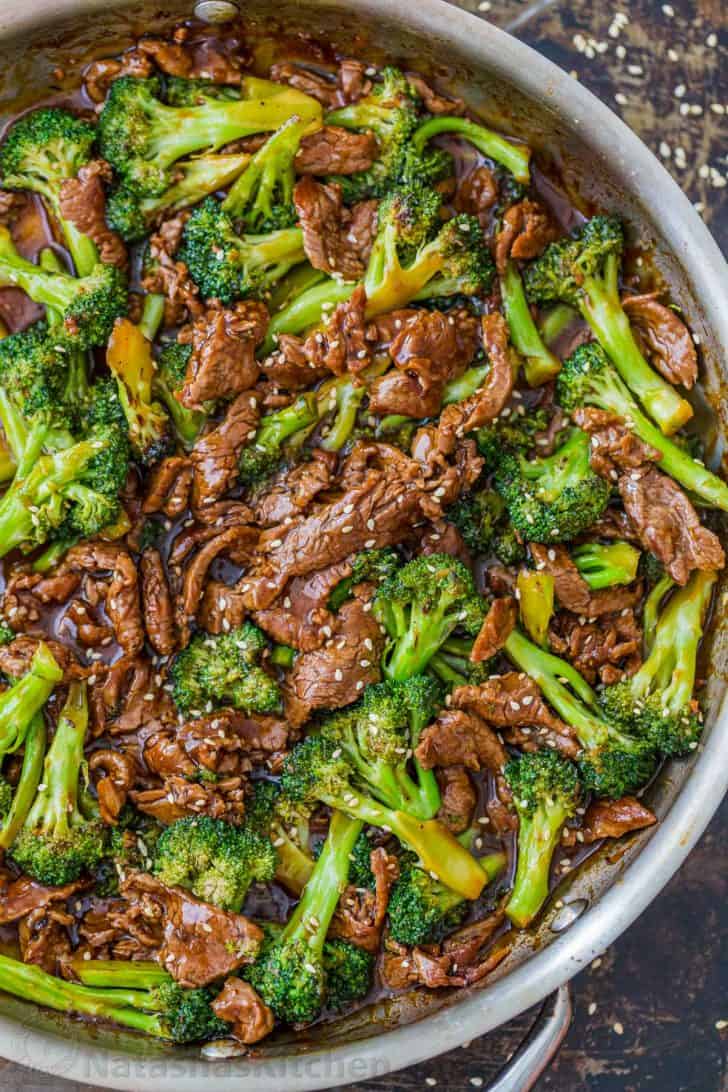 Beef and broccoli recipe in fry pan garnished with sesame seeds