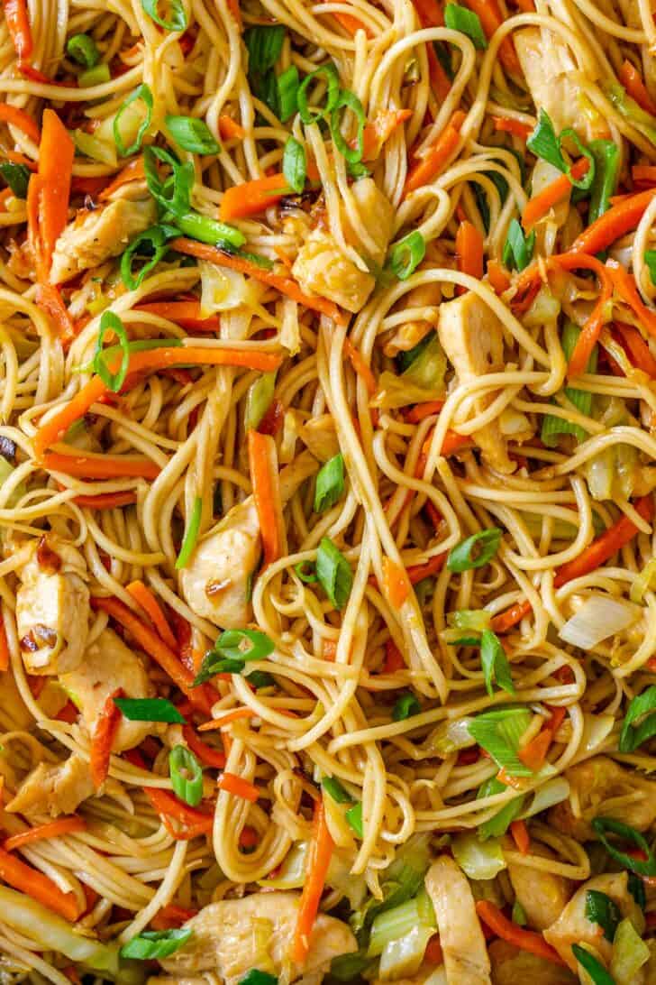 Chow mein with chicken and vegetables close up in pan