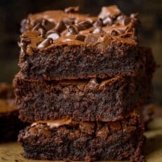fudgy brownies stacked on parchment paper