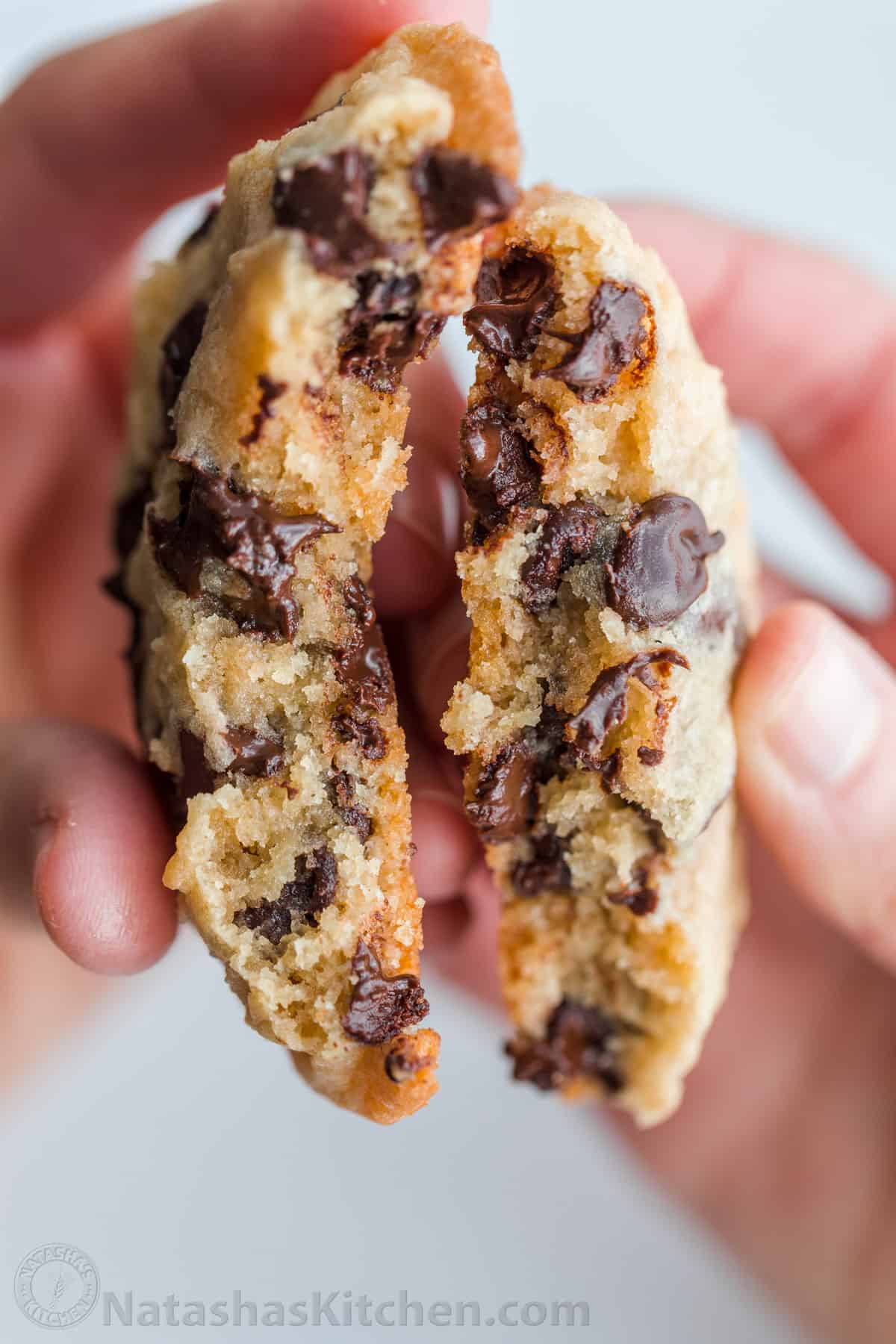 Soft chocolate chip cookies broken in half to show moist chocolatey center
