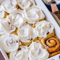 cinnamon rolls in casserole dish with icing on top