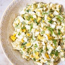 Potato salad sprinkled with dill in beige bowl