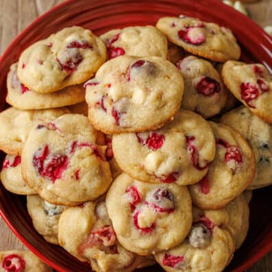 White chocolate cranberry cookies stacked on a red platter