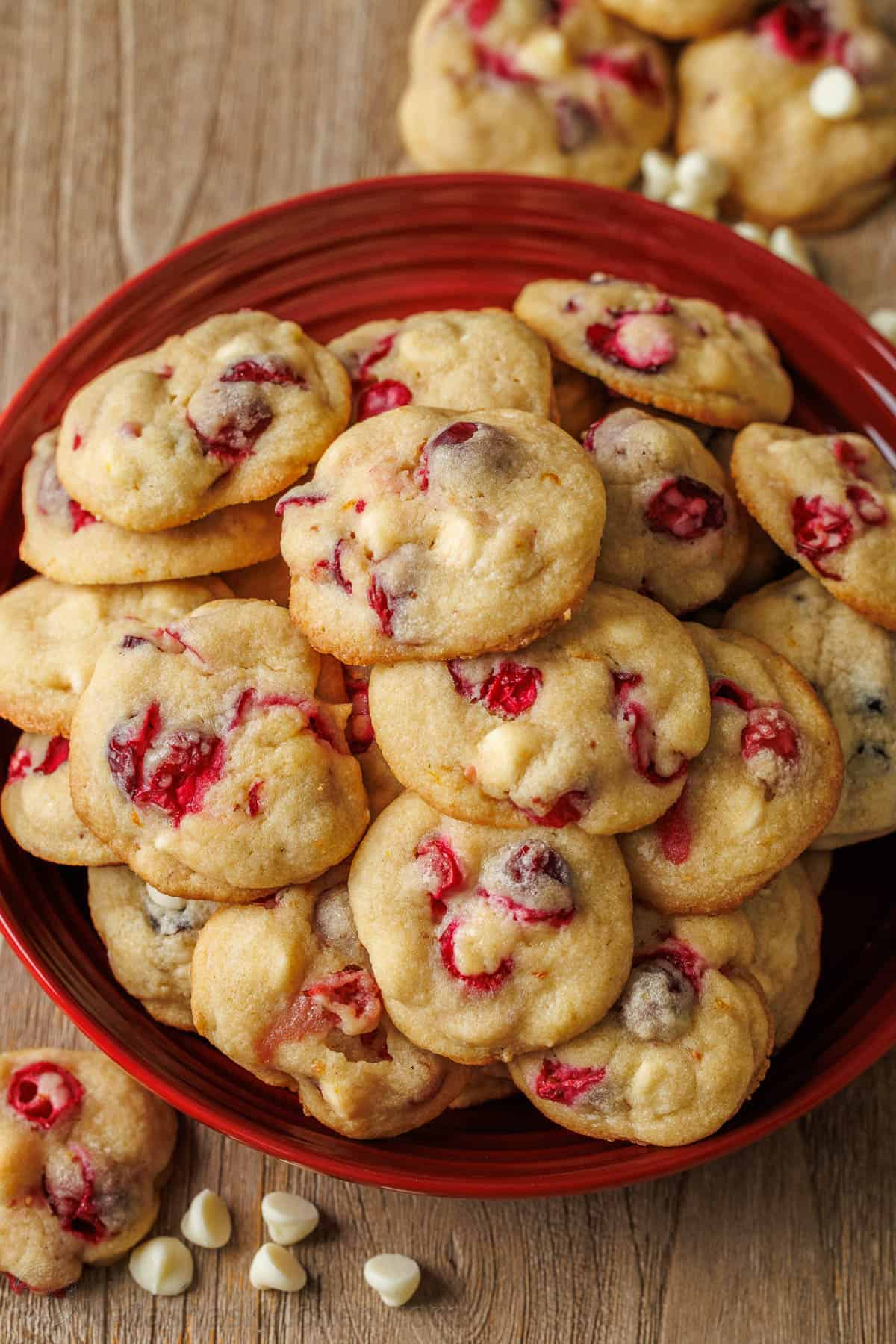 White chocolate cranberry cookies stacked on a red platter