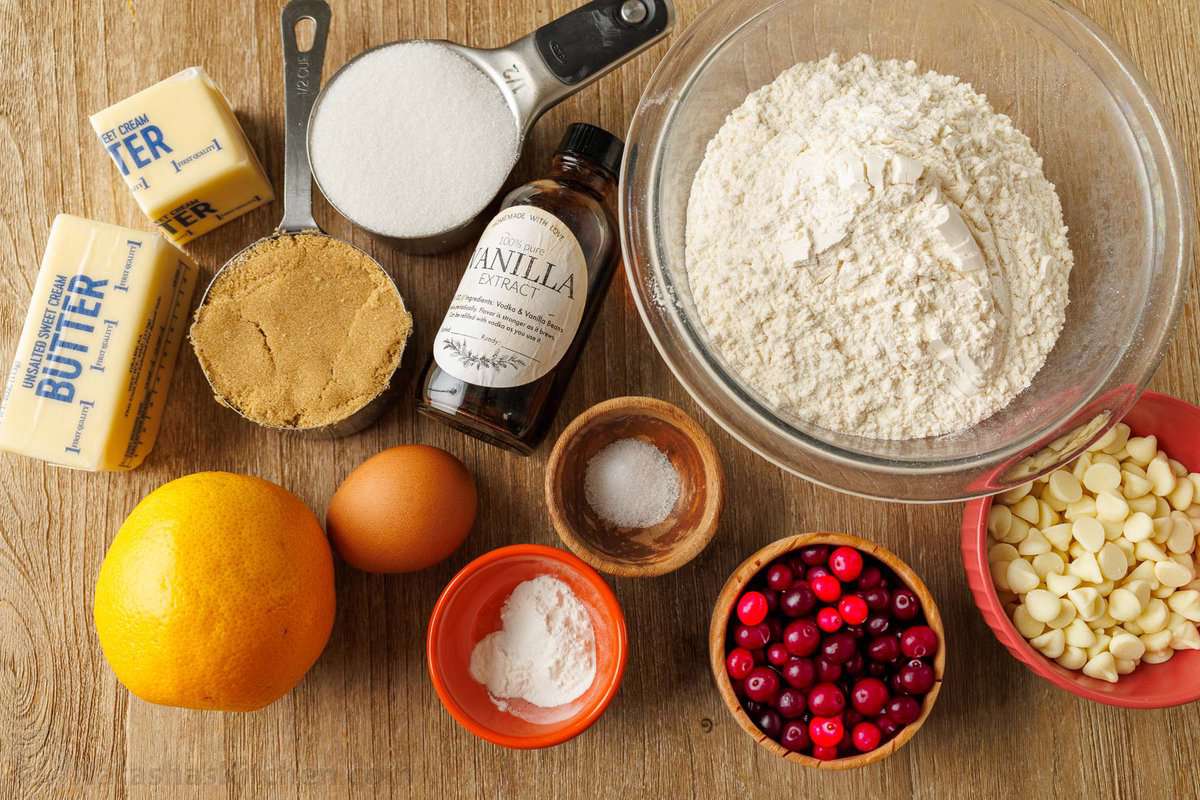 Ingredients for white chocolate chip cranberry cookies: cranberries, orange zest, brown sugar, sugar, vanilla, egg, baking powder, flour, butter, salt