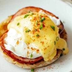 Eggs Benedict on a plate topped with hollandaise