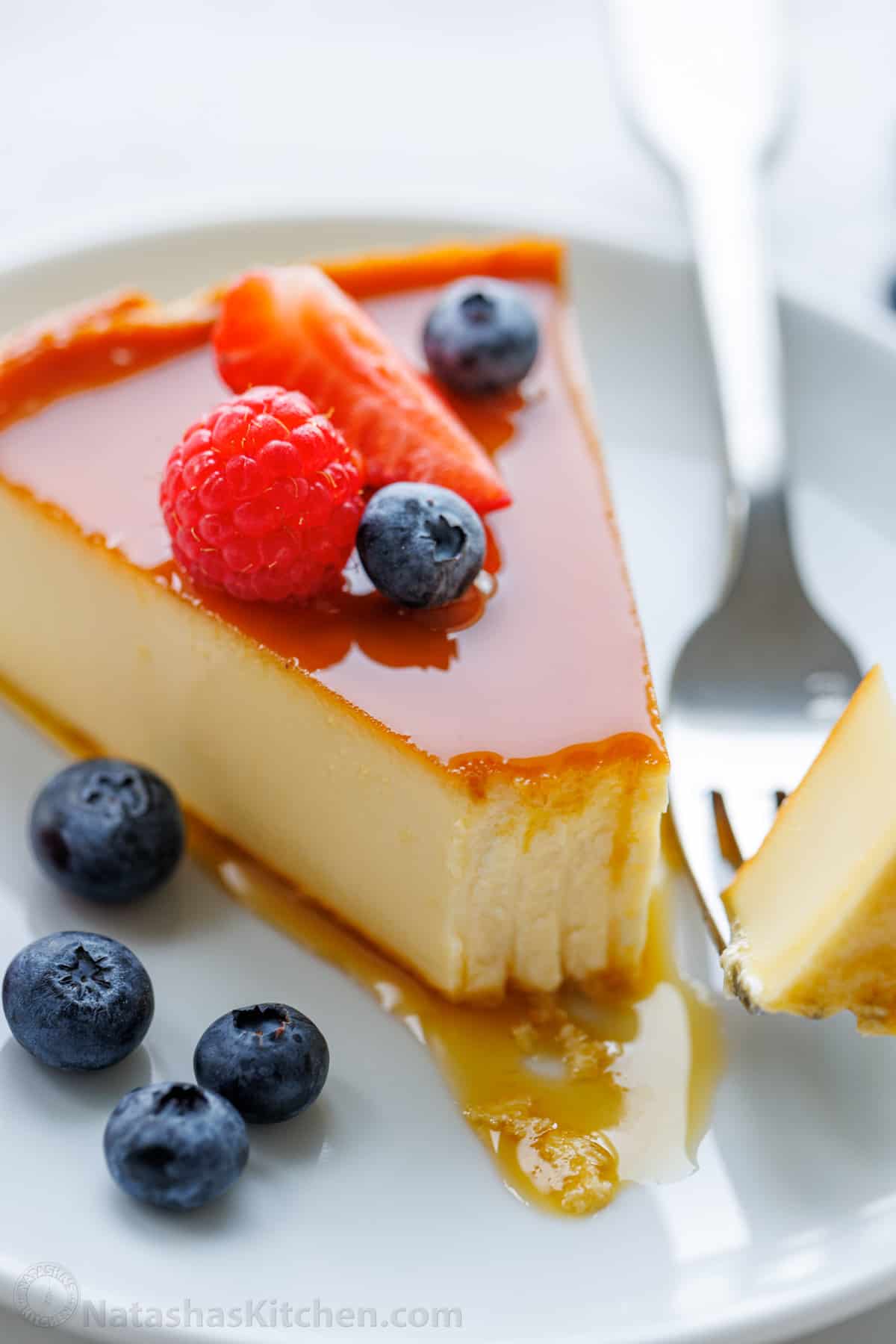 Slice of flan on a plate with forkfull