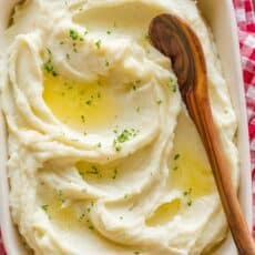 Instant Pot Mashed Potatoes in a casserole dish drizzled with butter