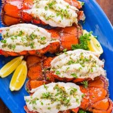 Broiled lobster tails on blue platter
