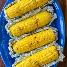 Grilled Corn in Foil on a blue platter