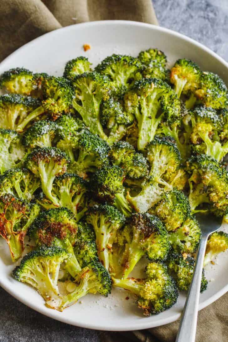 Oven roasted broccoli florets on a plate.