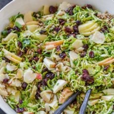Shaved brussels sprouts salad with salad servers