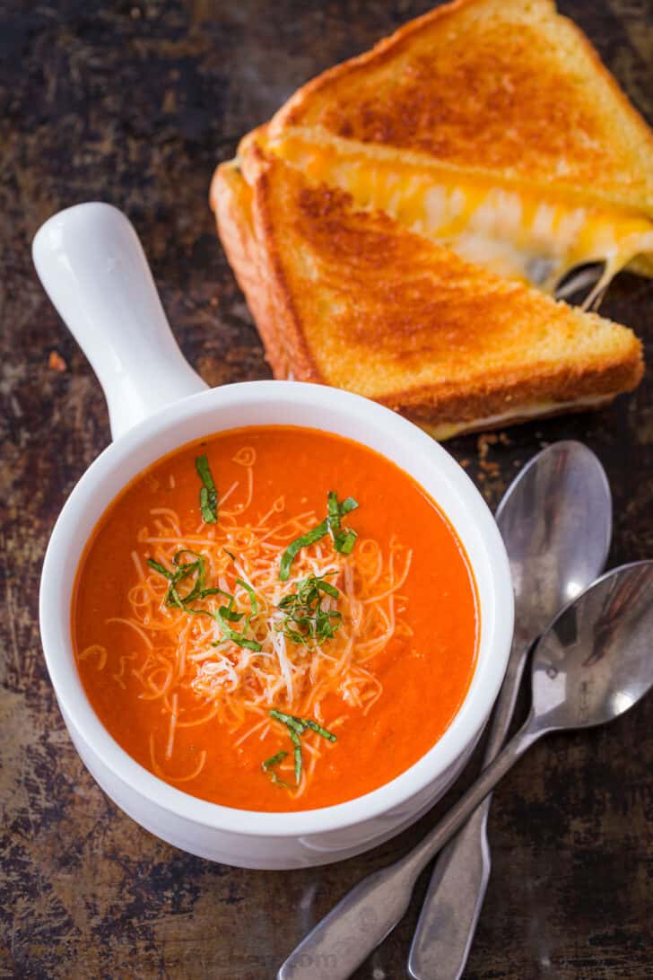 Creamy tomato soup served with grilled cheese sandwich