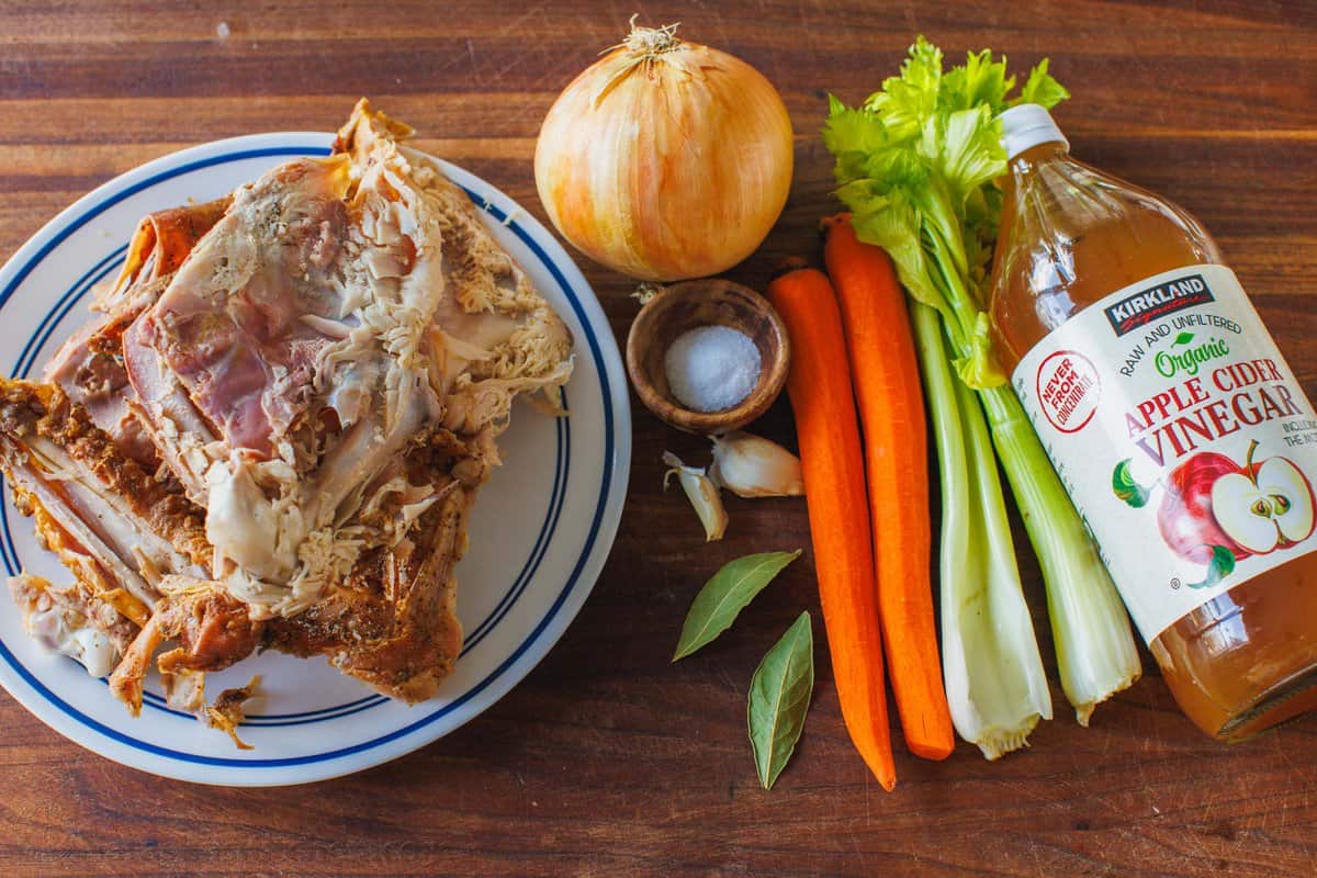 Turkey bones, onion, salt, garlic, bay leaf, carrots, celery stalk, and apple cider vinegar are ingredients for Turkey bone broth