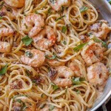 Tuscan Shrimp Pasta with sun-dried tomatoes in a stainless steel pan