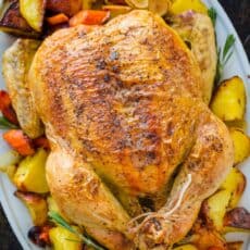 Whole Roast Chicken on a platter with vegetables